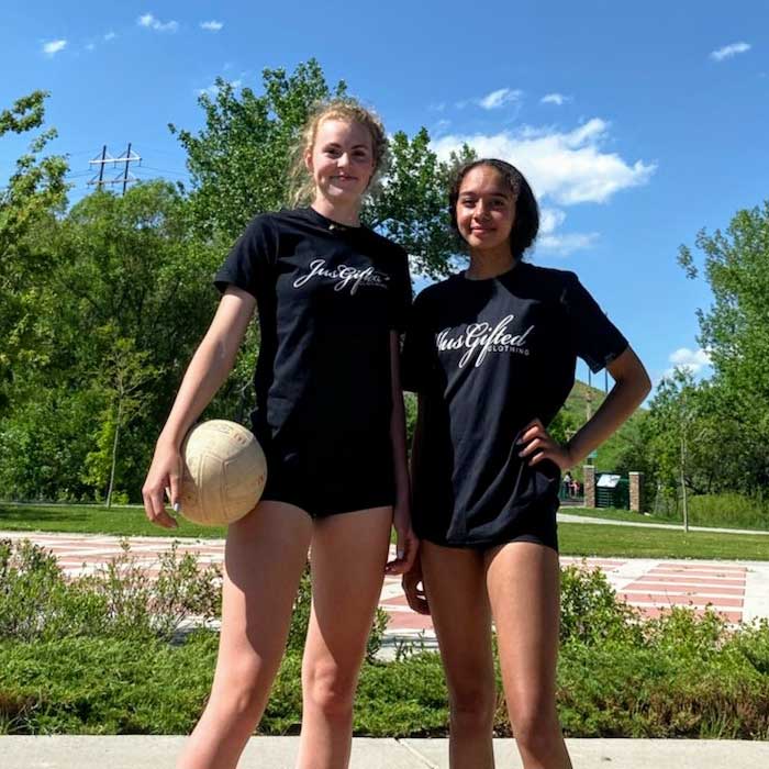 two girls holding volleyball while wearing Jus Gifted shirts