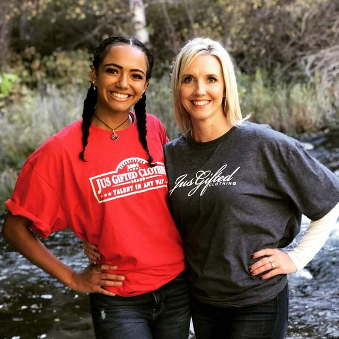 two women in front of a river wearing Jus Gifted shirt