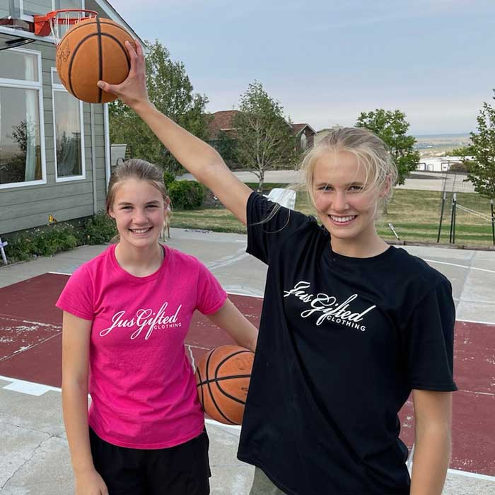 two girls holding basketballs while wearing Jus Gifted shirt